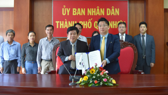 지난 19일 베트남 꾸이년시 청사에서 응오 호앙 남 시장과 노주현 HDC신라면세점 기획팀장이 업무협약(MOU)을 맺은 뒤 기념촬영을 하고 있다. <HDC신라면세점 제공>